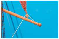 feste Part der Schot durch ein Loch in der Rah mit Stopperknoten fixiert